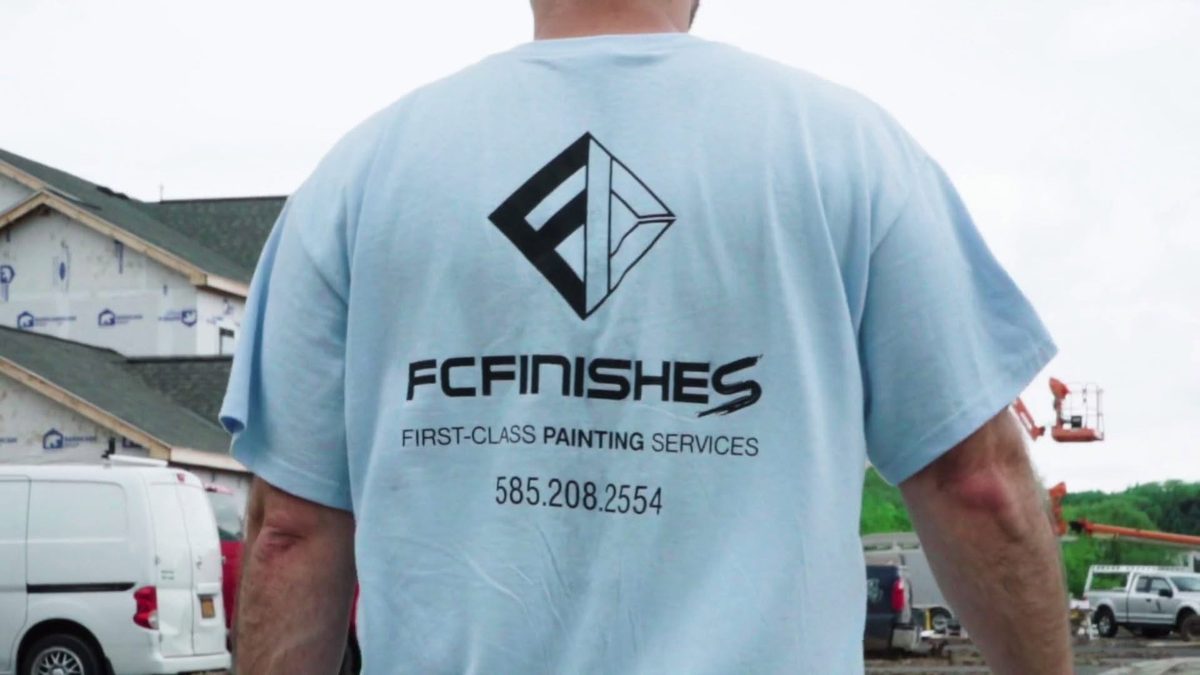 FC Finishes crew member on a Rochester, NY job site wearing a First-Class Painting Services shirt